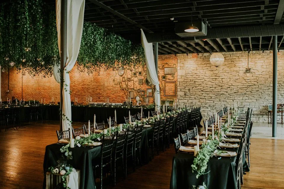 Long reception tables with hanging greenery at Brickyard on Main