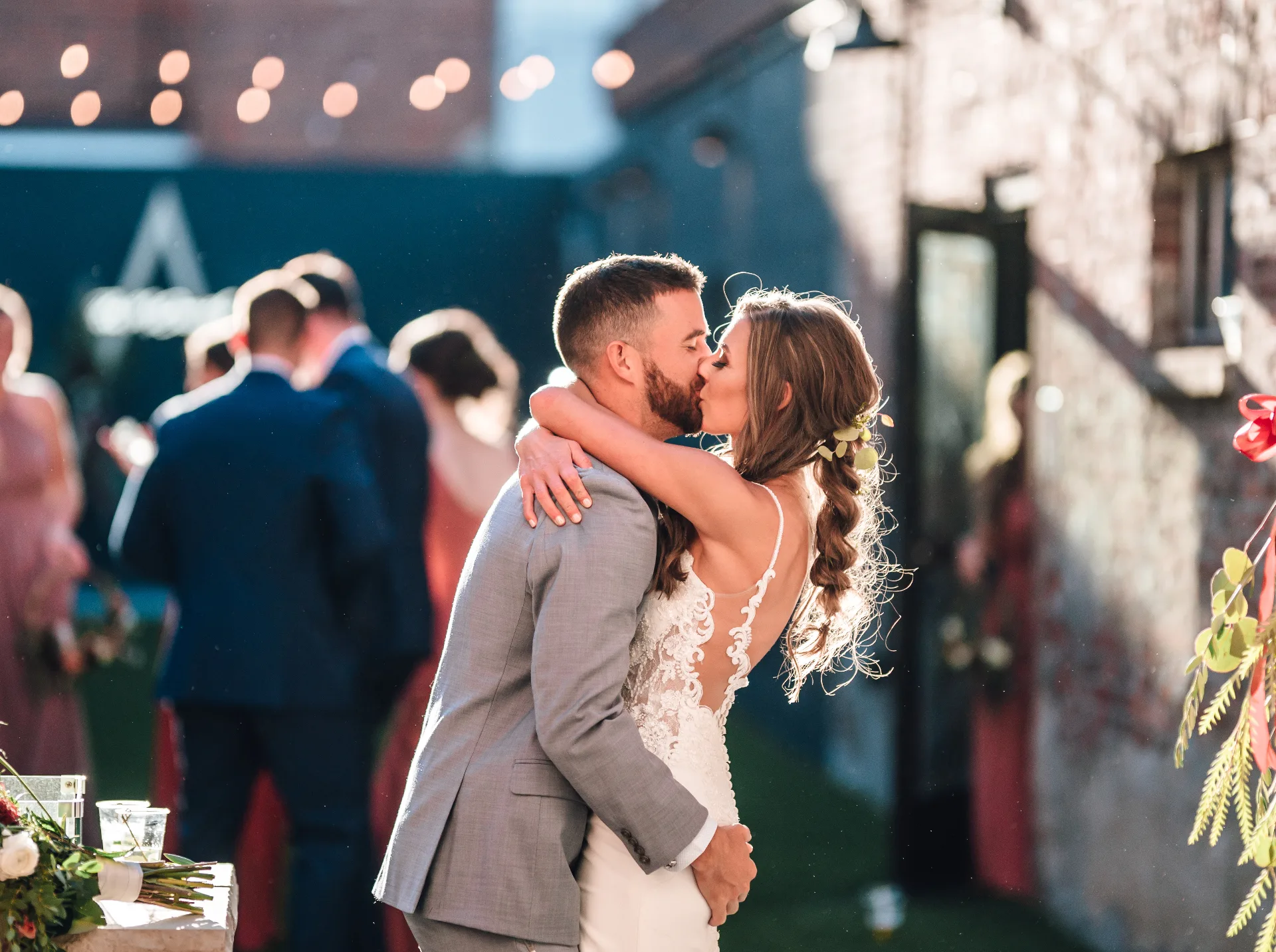 Couple kissing at golden hour in the Brickyard on Main courtyard